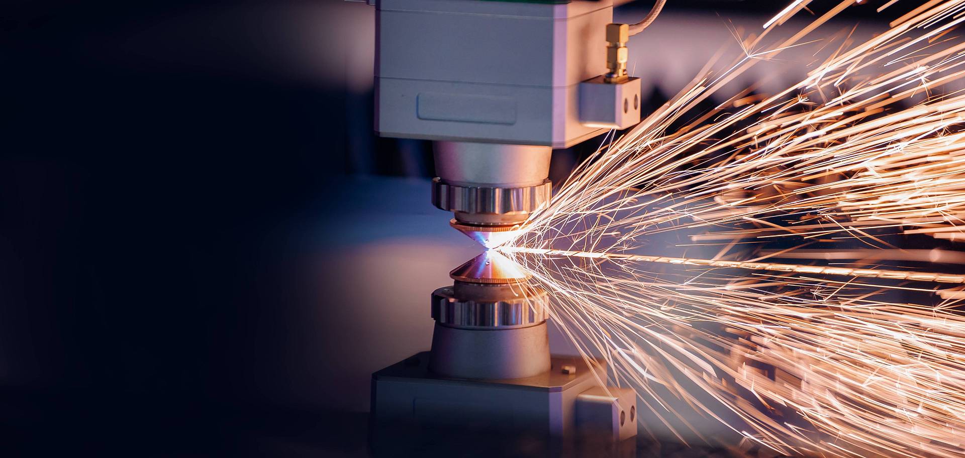 Laserschneidmaschine schneidet ein Metallwerkstück, während Funken sprühen.